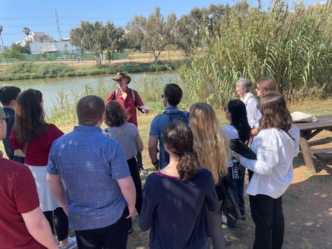 Students at Yarkon River Israel listening to tour guide 