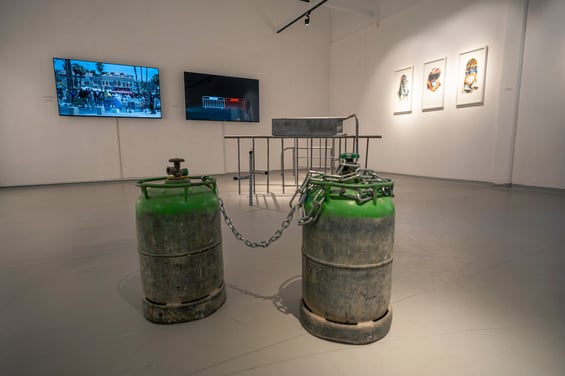 A collaborative art installation depicts chained industrial tanks at the Givat Haviva Art Gallery