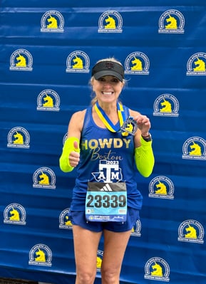 Carolyn Hoffmann ’89, ’23 poses at the end of the 127th Boston Marathon