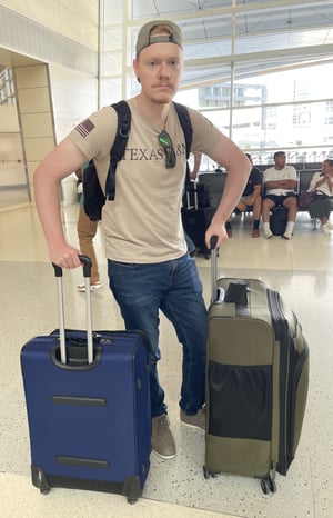 Student with luggage in airport awaits flight