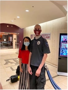 Wei Wu and a friend stand in the law school front lobby