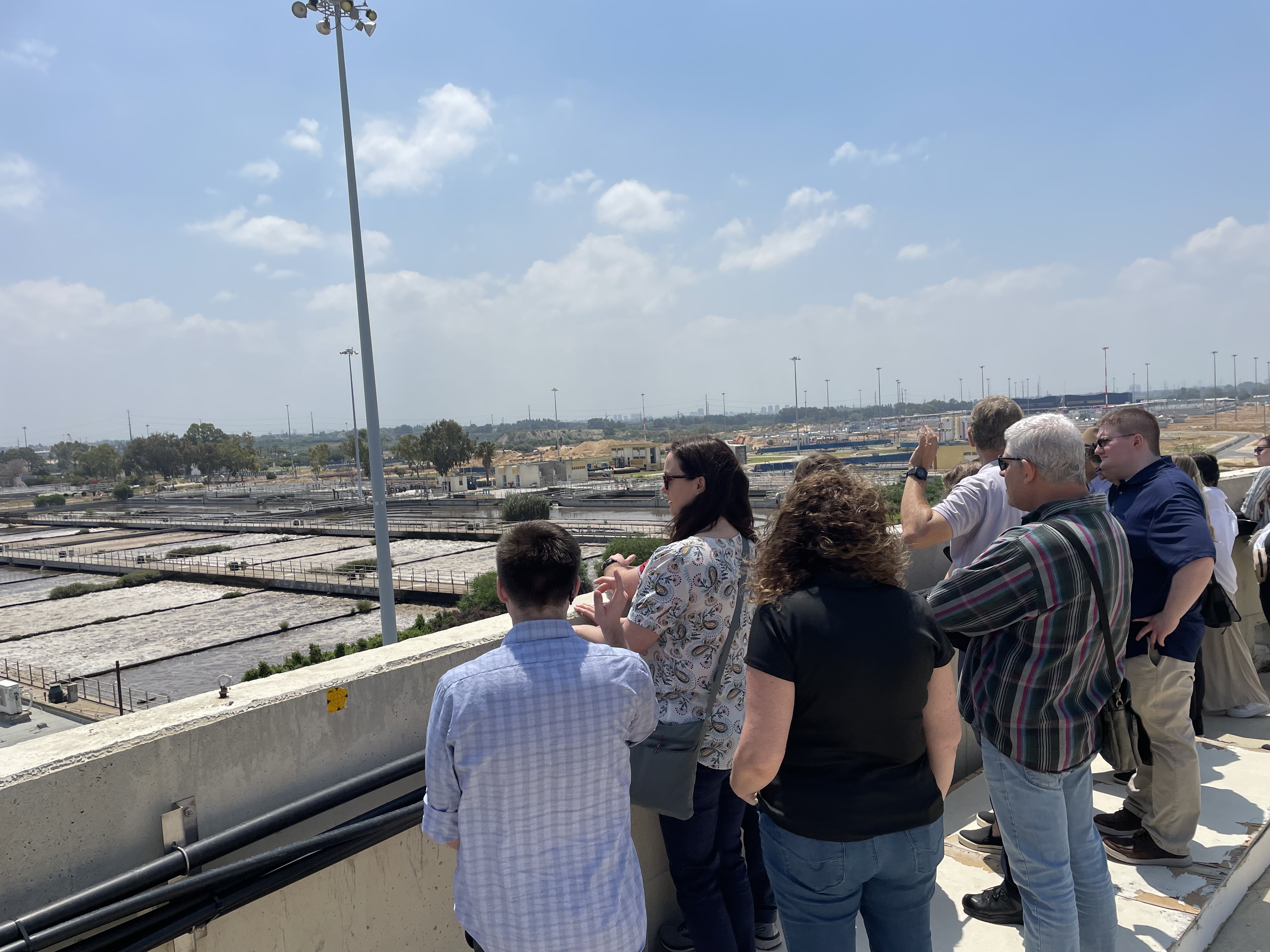 Texas A&M students visiting the Shafdan Wastewater Treatment Plant peer out at the bioreactor pools where bacteria progressively break down organic material as the water flows through each of the pools.