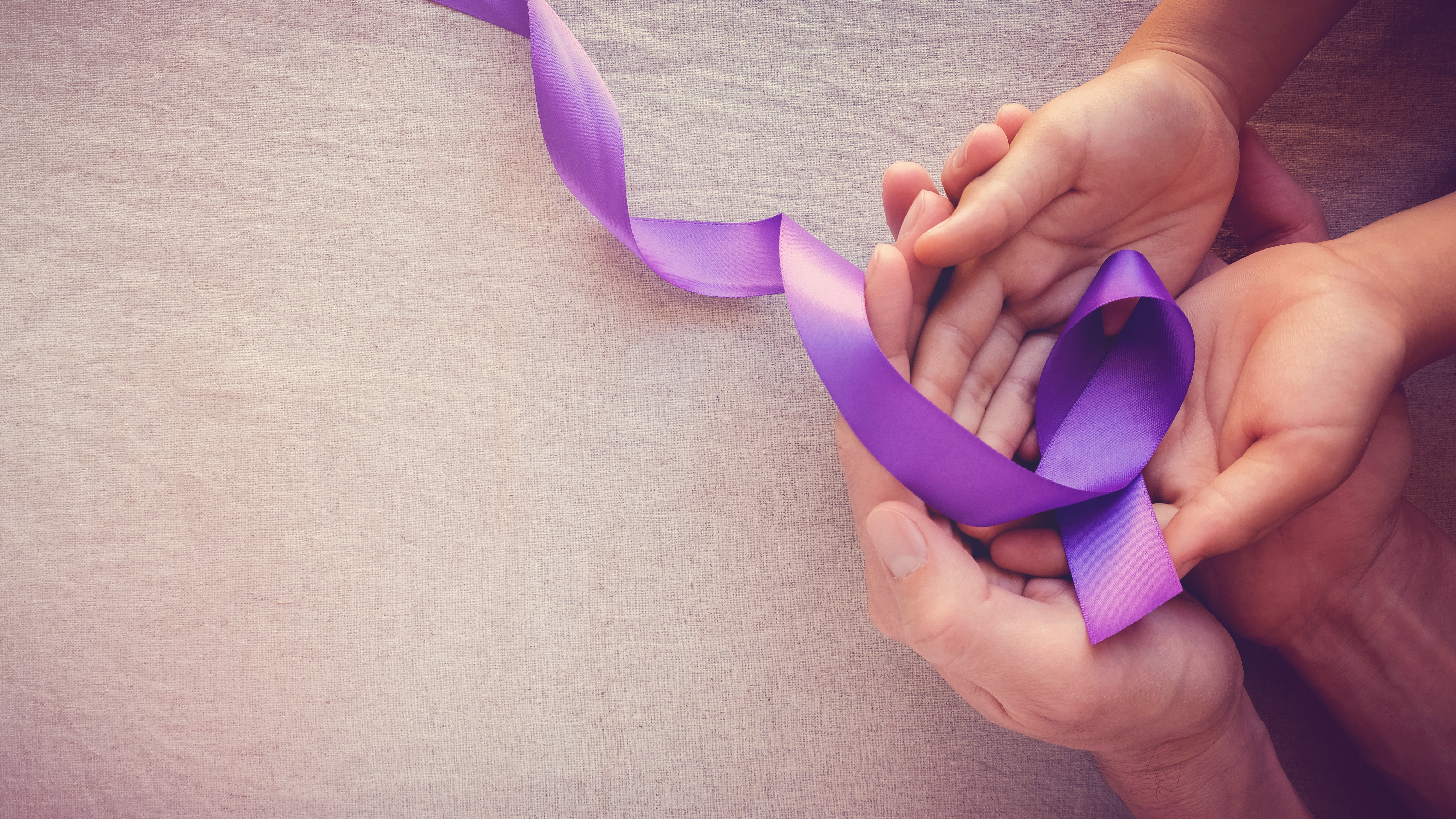 A family holding a purple domestic violence ribbon